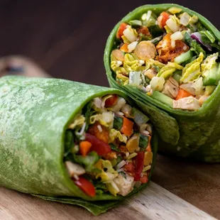 a close up of a vegetable wrap on a cutting board