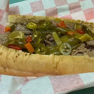 a beef sandwich with peppers and onions