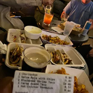people sitting at a table with plates of food