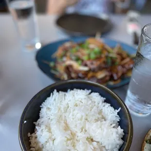 a bowl of rice and a bowl of water on a table