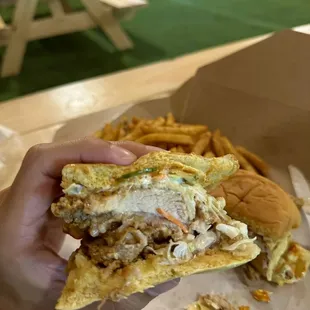 a person holding a sandwich and french fries