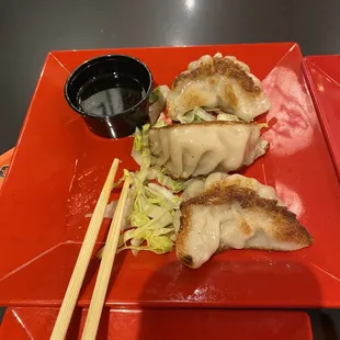a plate of dumplings and chopsticks