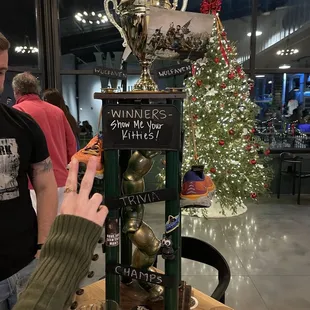a man taking a picture of a trophy