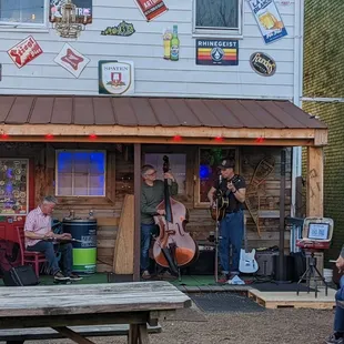 a group of people sitting at picnic tables in front of a building