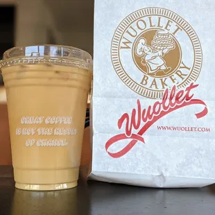 a cup of coffee next to a paper bag