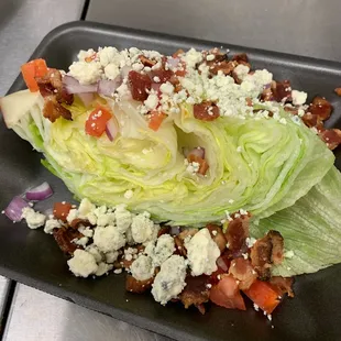 ws a wedge of lettuce with bacon, onions, blue cheese,