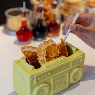 a person holding a cigarette in a yellow container