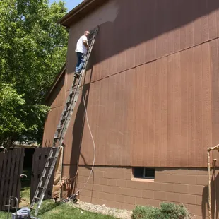 Wyman Painting crew member painting a house in NW Omaha.