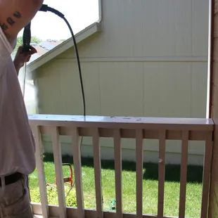 Brandon Wyman power washing a railing pounded by May 11 2016 hail storm in Omaha.