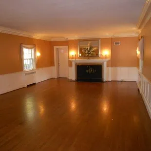 Huge open ballroom with giant original fireplace. Beautiful custom woodwork!