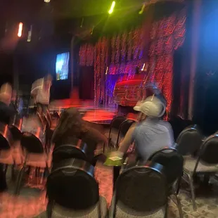 a group of people sitting in chairs in front of a stage