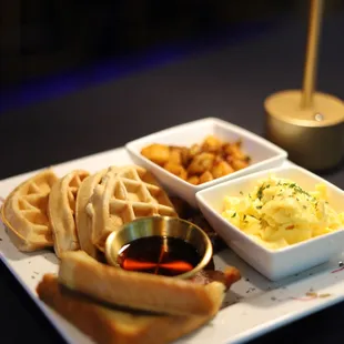 a plate of waffles, eggs, and hash browns