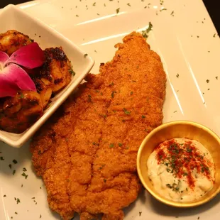 a plate of fried chicken and a bowl of dip