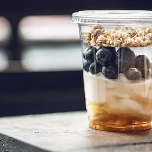 a cup of yogurt with blueberries and granola