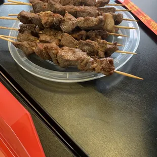 a plate of meat skewers