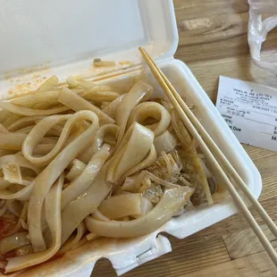 noodles in a styrofoam container with chopsticks