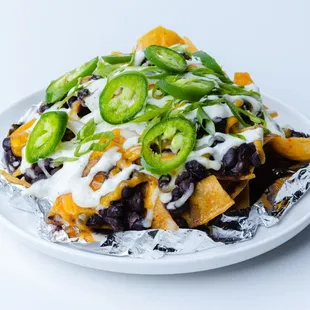 a plate of nachos topped with cheese and jalapenos