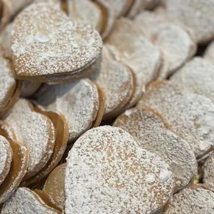 ALFAJORES - Two buttery, melt-in-the-mouth cookies filled with creamy caramel &amp; topped w/ sprinkled powdered sugar.