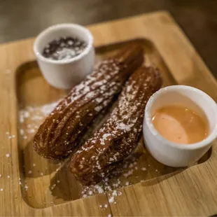 a plate of churros and dipping sauce