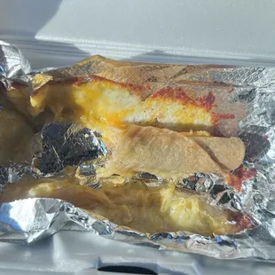 Rolled tacos with cheese stuck to the foil, but not on my road Taco. Everybody knows rolled tacos  come with guacamole.