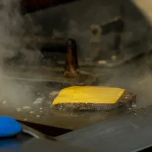 a burger being cooked in a frying pan
