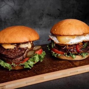 two burgers on a cutting board