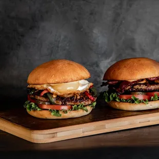 two burgers on a cutting board