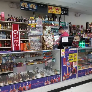 a woman at the counter of a liquor shop