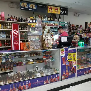 a woman at the counter of a liquor shop