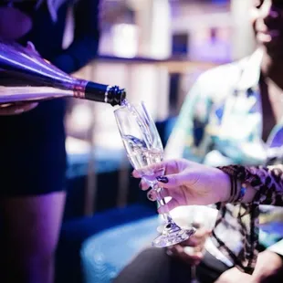 a woman pouring a glass of champagne