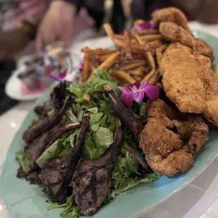 5 pieces of lamb chops, 4 pieces of fried chicken and 3 pieces of beef. A plate full of salad and fries