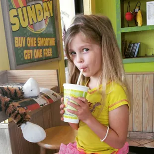 a little girl drinking a drink