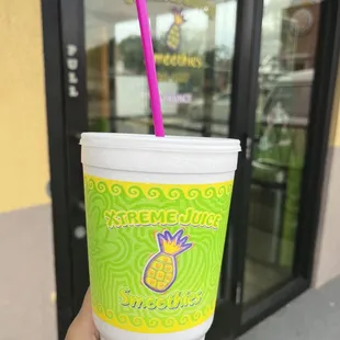 a hand holding a cup with a straw