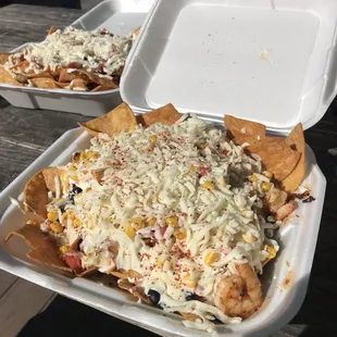 Grilled Shrimp nachos with elote cup on top in the front. In the back is tempura shrimp nachos.