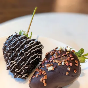 two chocolate covered strawberries on a plate