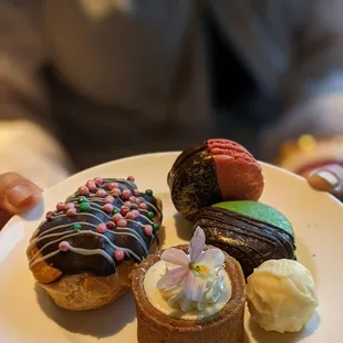 a person holding a plate of pastries