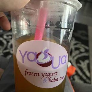 a hand holding a cup of yogurt