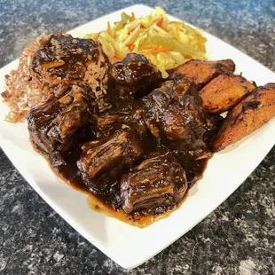 Oxtail a House Favorite Dinner: Oxtail, plantains, rice and beans and veggies