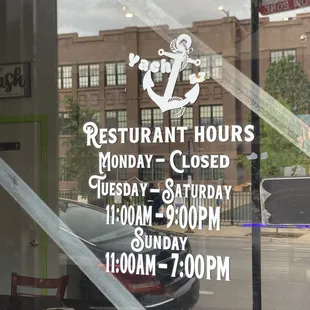 a restaurant hours closed sign in a window