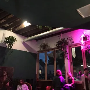 a group of people sitting and standing in a dimly lit room