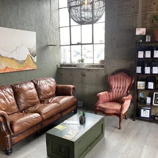a living room with a brown leather couch and two chairs