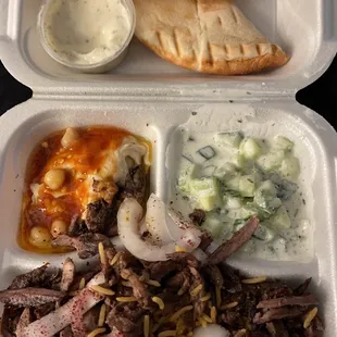 Beef Shawerma entree. Side of rice, pita, hummus, cucumber salad, and tahini sauce.
