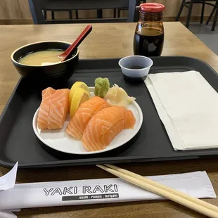 a plate of sushi and chopsticks