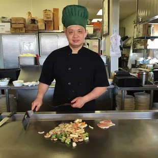 Chef cooking food in front of me.
