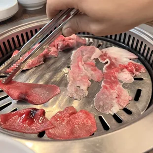 a person chopping meat on a grill