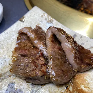 two pieces of meat on a cutting board