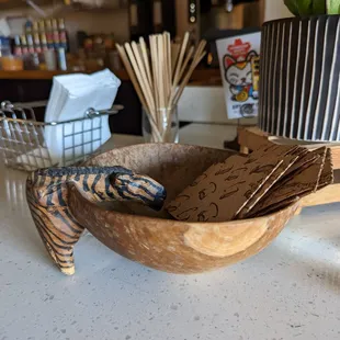 a wooden bowl with a lizard in it