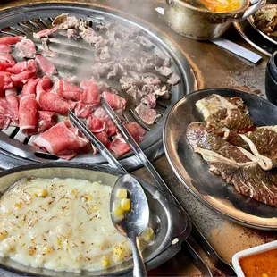 a variety of meats being cooked on a grill