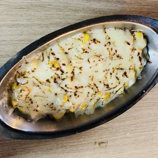 a dish of mashed potatoes on a wooden table