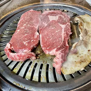two steaks on a grill
